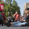 Student using laptop at bell tower on campus