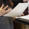 Two students at a Career Fair holding a resume and padfolio